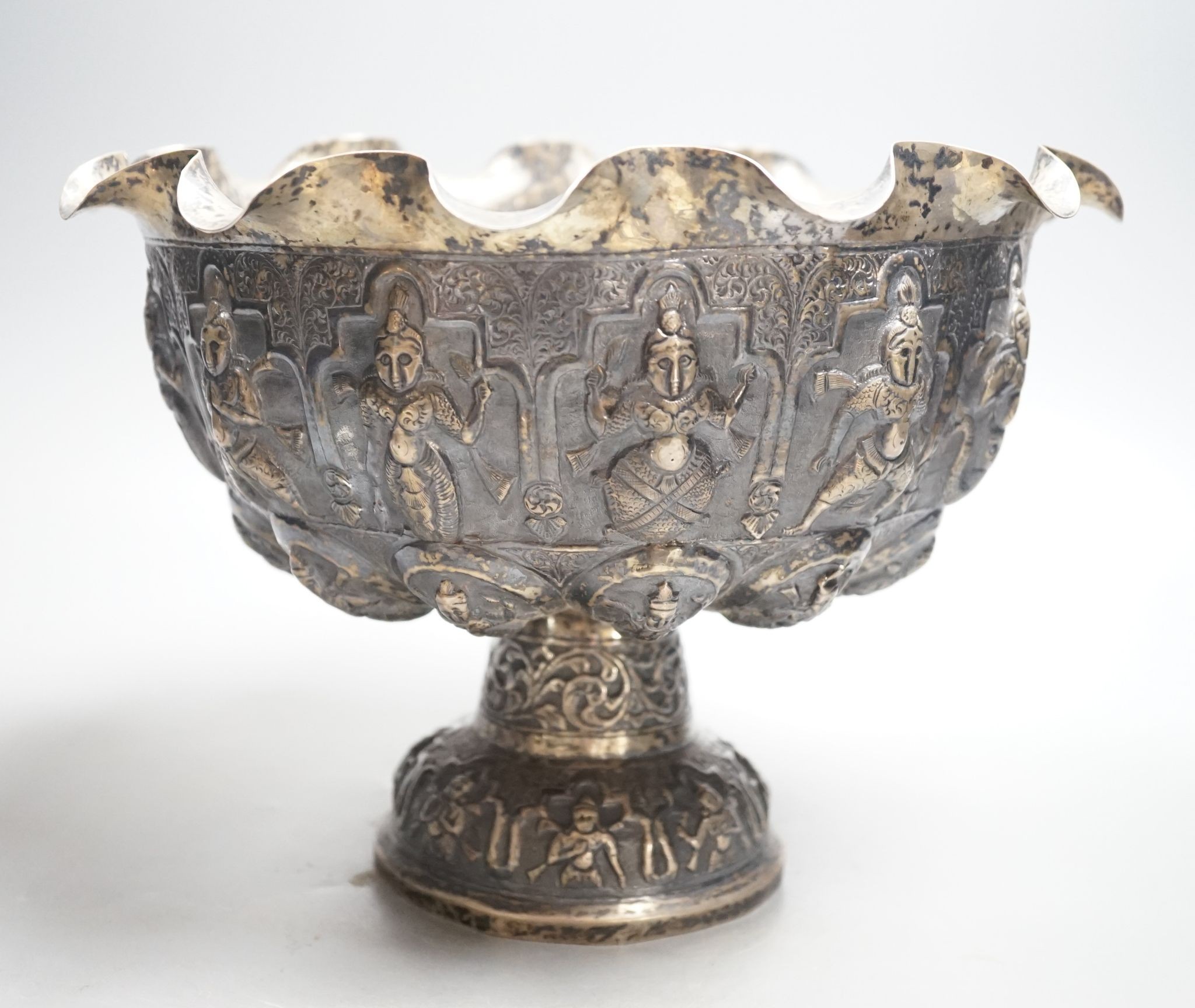 A late 19th century Burmese embossed white metal pedestal bowl, with wavy border, diameter, 27.2cm, 20.5oz.